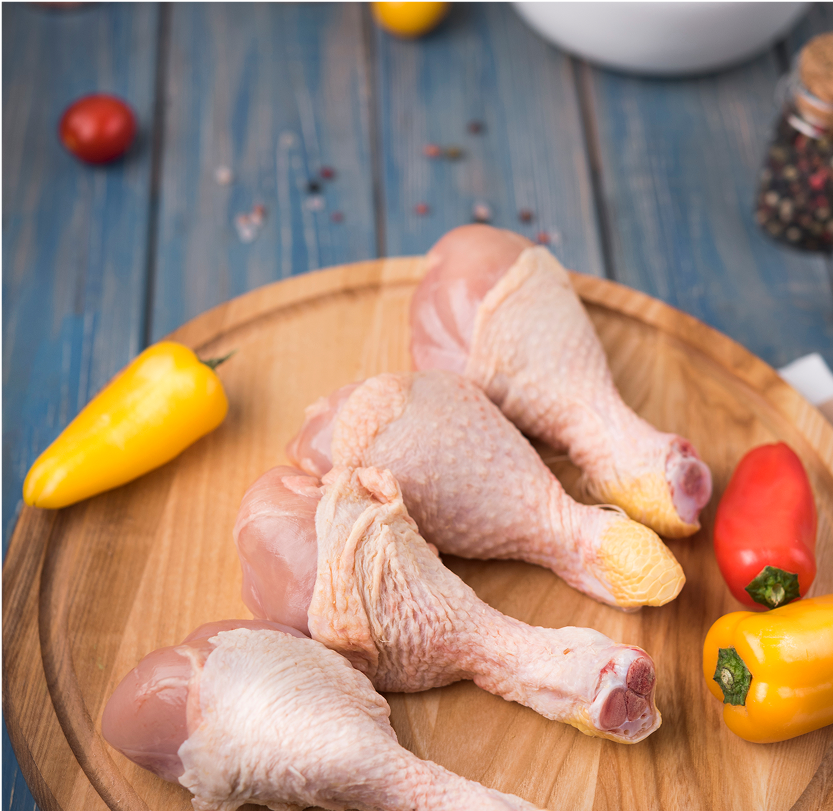high-angle-chicken-drumsticks-wooden-board-with-peppers-tomatoes